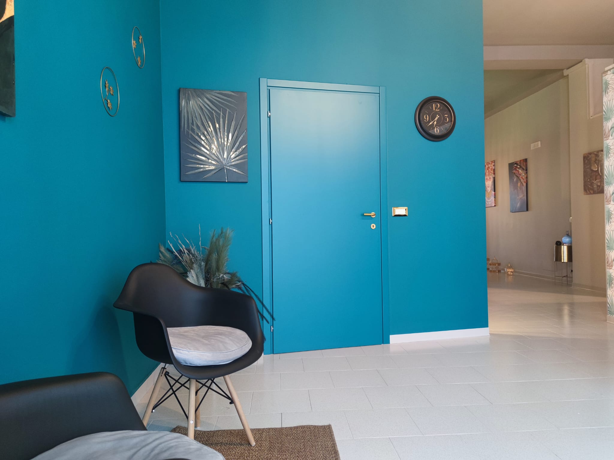 Sala d'attesa con parete teal e arte parietale
